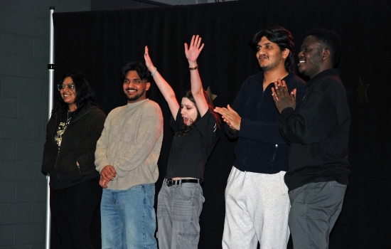 Students cheer and clap on the SLC stage