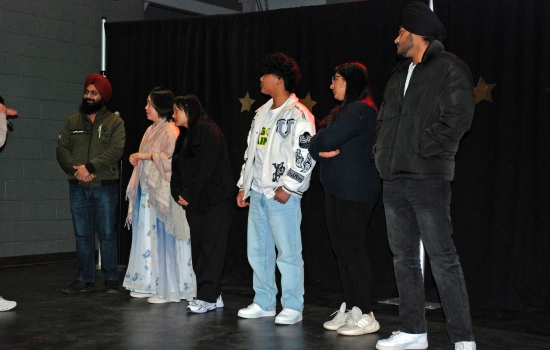 A group of students stands on the SLC stage
