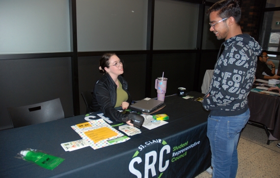 A student speaks with Natalie at the SRC table. 