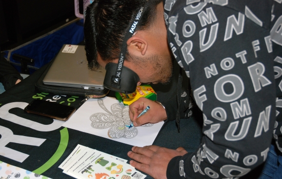 A student attempts to colour while wearing the impairment goggles