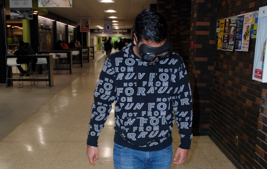 A student attempts to walk a straight line while wearing the impairment goggles
