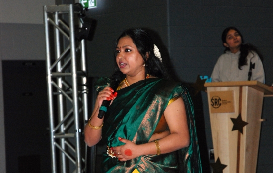 A student in traditional Indian dress speaks to the crowd about what they're wearing