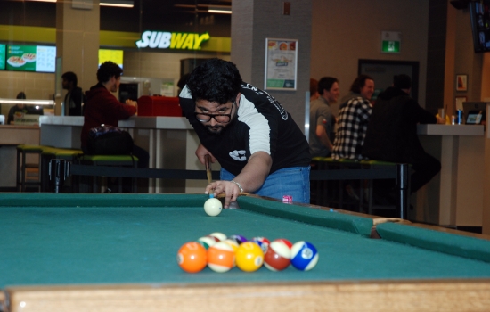 A student lines up their shot on the pool table