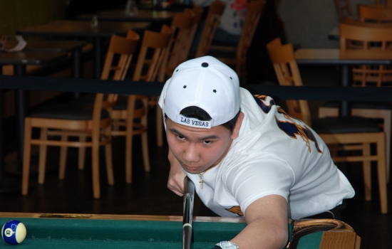 A student lines up their shot on the pool table