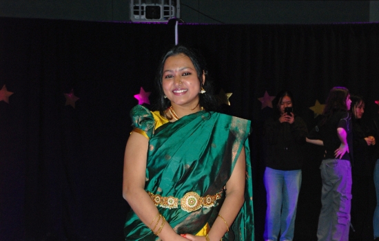 A student models their cultural ensemble on the runway