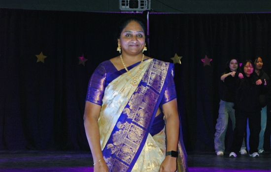 A student models their cultural ensemble on the runway