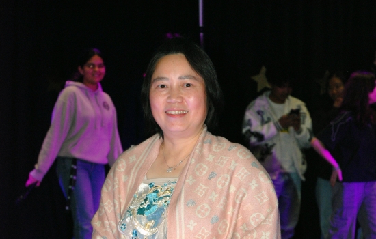 A student models their cultural ensemble on the runway