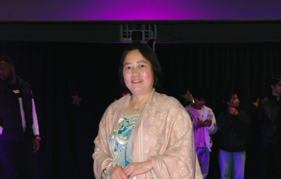 A student models their cultural ensemble on the runway