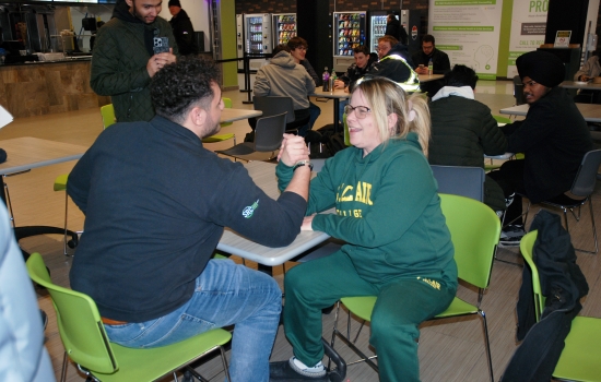 A student arm wrestles Ali
