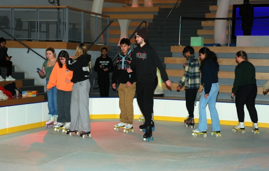 A group of students skate around the SLC