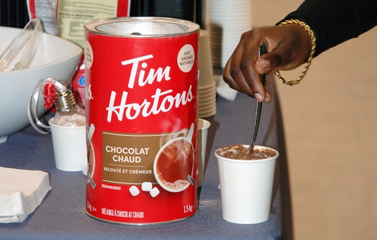 A student stirs their hot chocolate