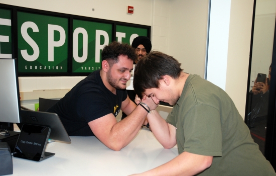 A student arm wrestles Ali in the copy centre
