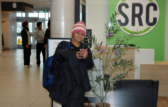 A student takes a selfie with the SRC condom tree