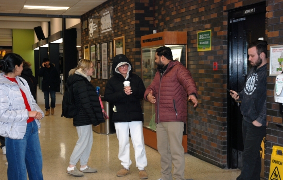A student tries to convince people wearing glasses to follow him 