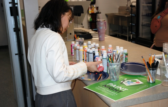 A student selects their paint supplies