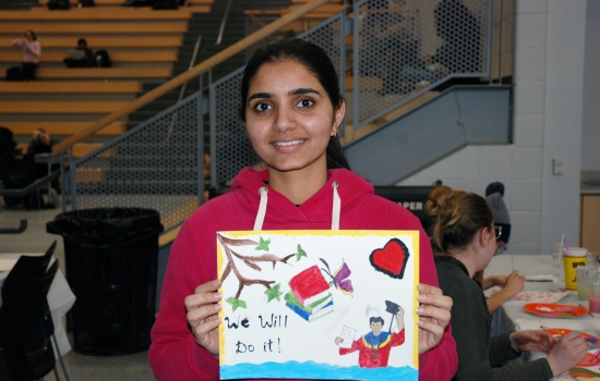 A student shows off their painting 