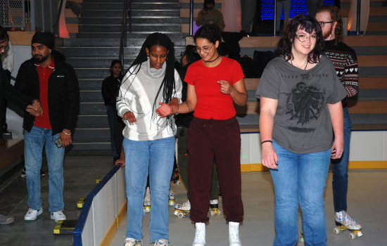 A group of students skate around the SLC