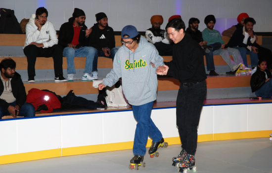 Students help each other balance on skates