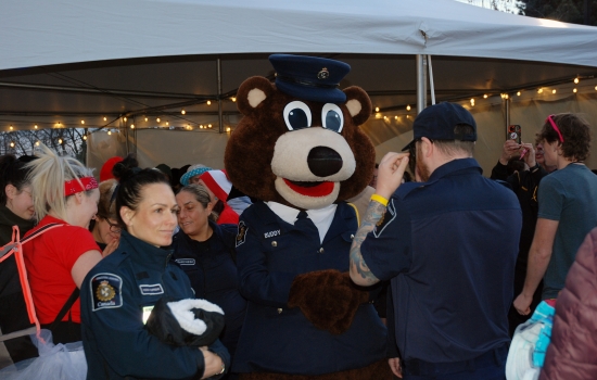 A bear mascot with police officers