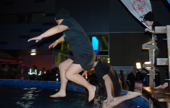 Two plungers in mid air over the pool