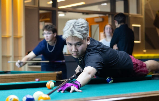 A student lines up his pool shot