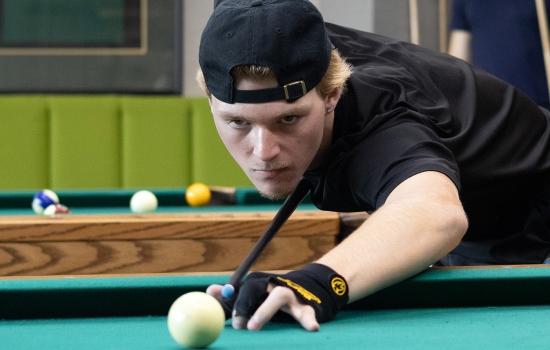 A student lines up his pool shot
