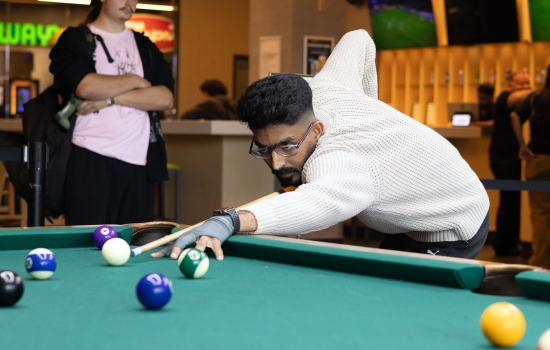 A student lines up his pool shot
