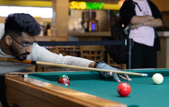 A student lines up his pool shot