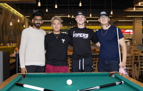 Participants of the Pool Tournament pose behind the pool table