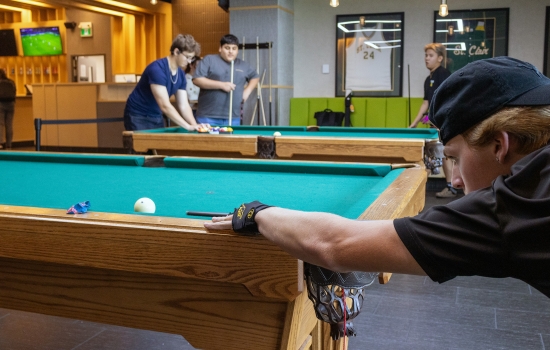 A student lines up his pool shot