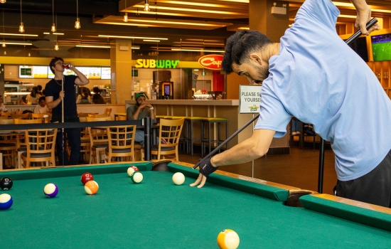 A student lines up his pool shot