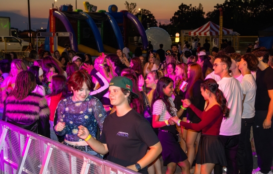 A concert crowd in front of a stage barrier 