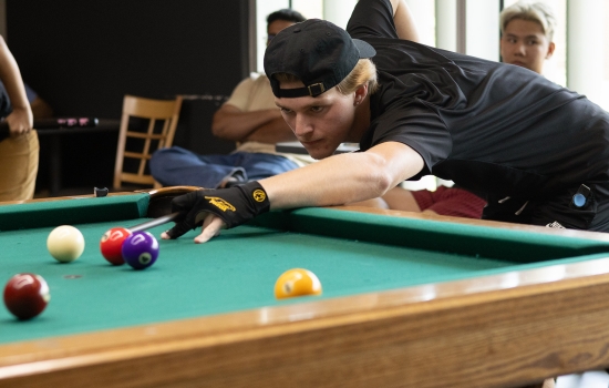 A student lines up his pool shot