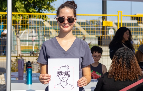 A student shows off her caricature