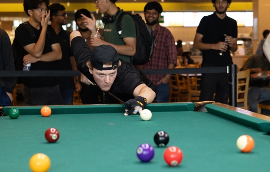 A student lines up his pool shot
