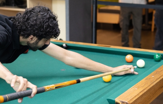 A student lines up his pool shot
