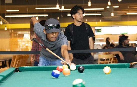 A student lines up his pool shot