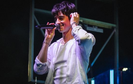 Elijah Woods smiles and performs on a stage