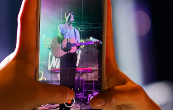 A smart phone takes a photo of Elijah Woods on stage