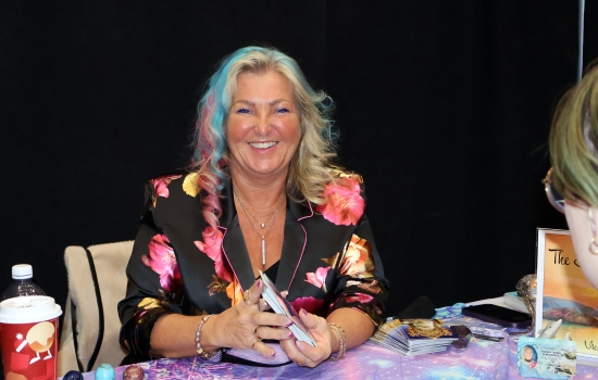 A medium smiles for the camera during a reading