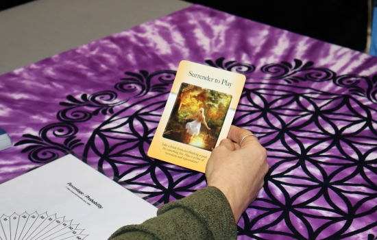 A student holds a card that reads "surrender to play"