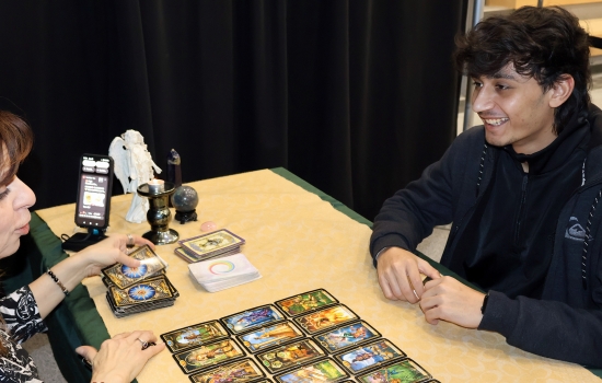 A student smiles as the medium explains his cards