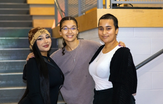 Three students smile for the camera
