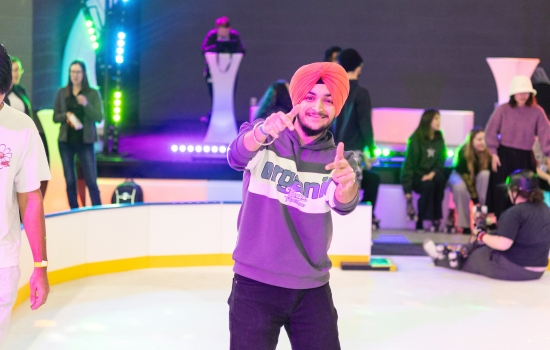 A student gives thumbs up to the camera while skating the rink