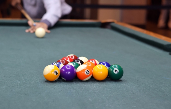 A student leans in for their pool shot in Griff's