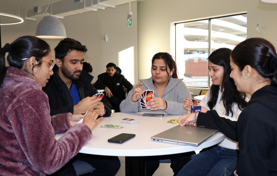 5 students play Uno at a round table