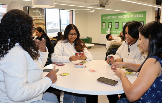 4 students play Uno at a round table