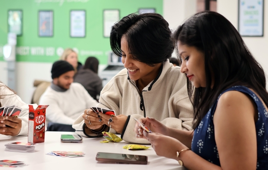 Smiling students play a game of UNO