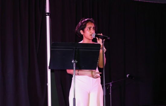 A contestant sings into a microphone on the SLC stage