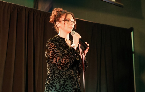 A contestant sings into a microphone on the SLC stage